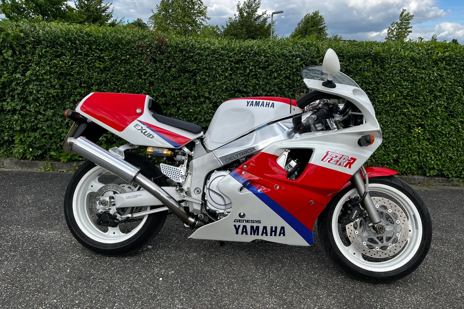 Yamaha FZR 750 R OW01 in Weiß-Rot vor einer Hecke